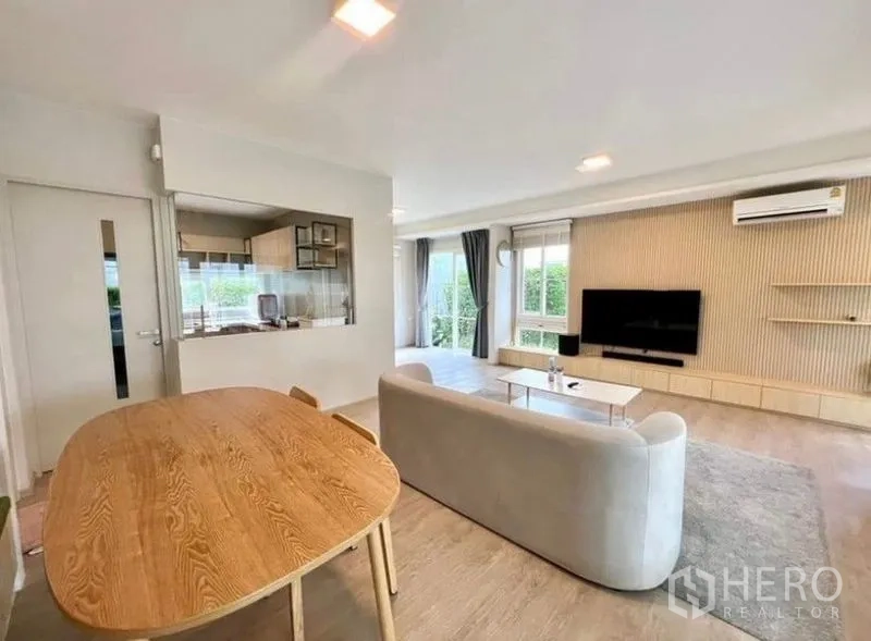 Detached House for rent - Living room with sofa, TV wall, dining table and view toward the kitchen.
