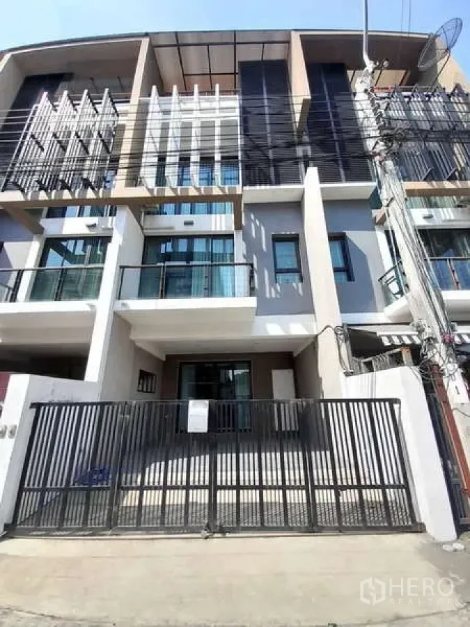 Townhouse for rent in Khlong Toei, Bangkok - Front exterior of the Khlong Toei townhouse with balcony railings and gate.