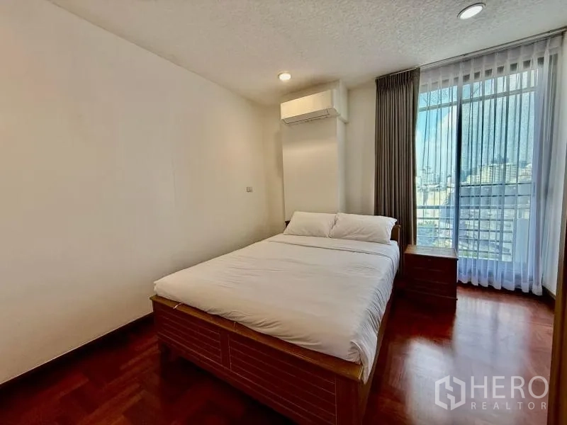 Condominium for rent - Bedroom with double bed, large window, sheer curtains, and city view.