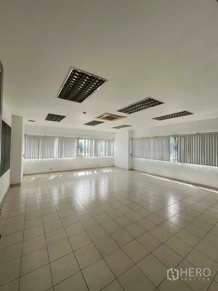 Warehouse for rent in Lat Krabang, Bangkok - Corner office space with blinds, tiled floor and ceiling lights.