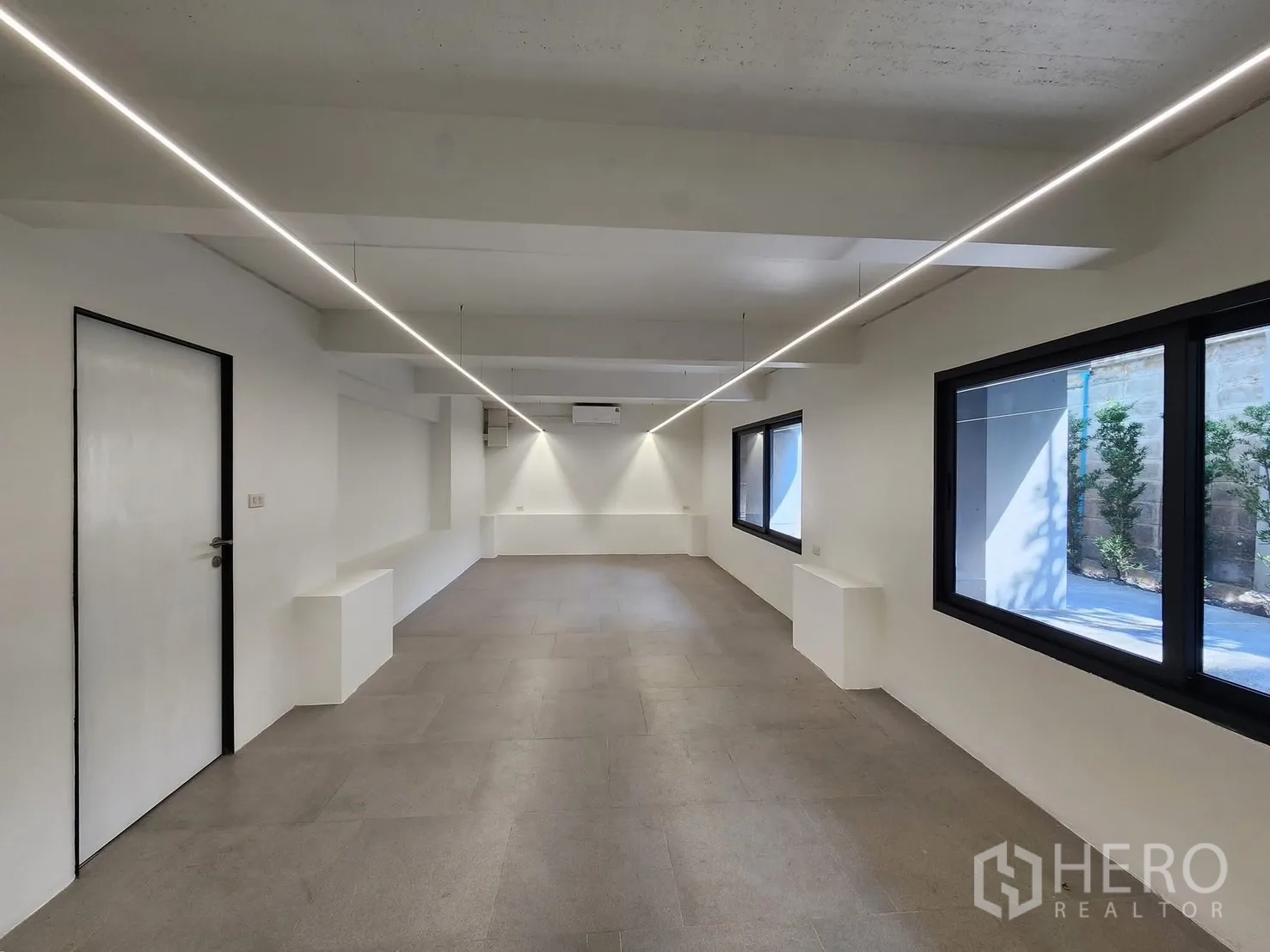 Home Office for rent in Chatuchak, Bangkok - Ground-floor workspace with tiled flooring, white walls, and long linear lighting.