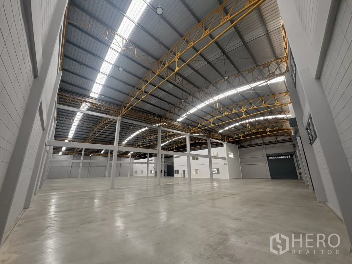 Factory for rent in Bang Phli, Samut Prakan - Open warehouse floor with integrated office block and a large sectional door.