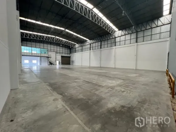 货栈 出租在Lat Krabang, Bangkok - 高挑库厅，天窗采光与大型卷闸出入口。