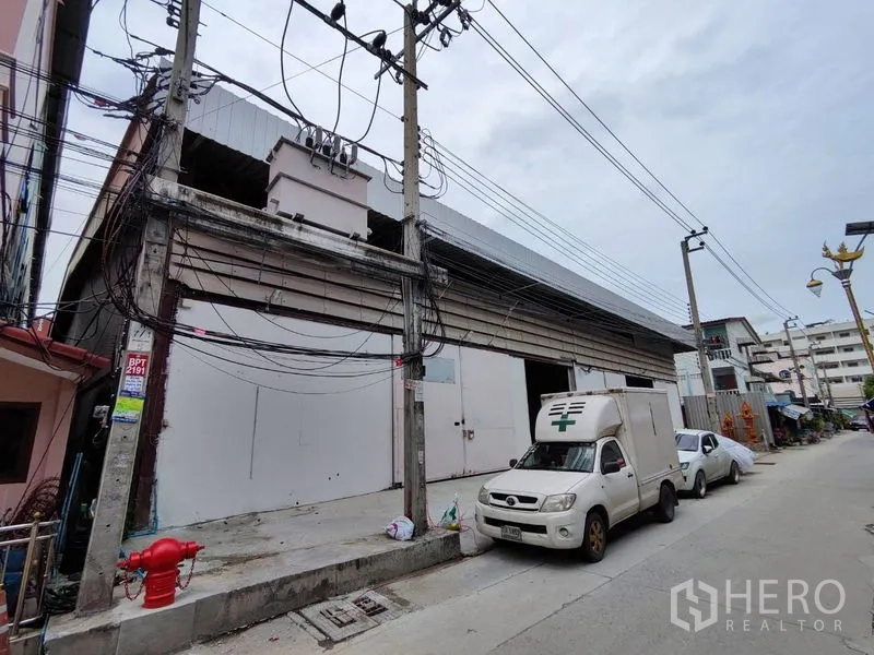 Warehouse for rent in Bang Phli, Samut Prakan - Street-front warehouse exterior with wide sliding doors and easy truck access.