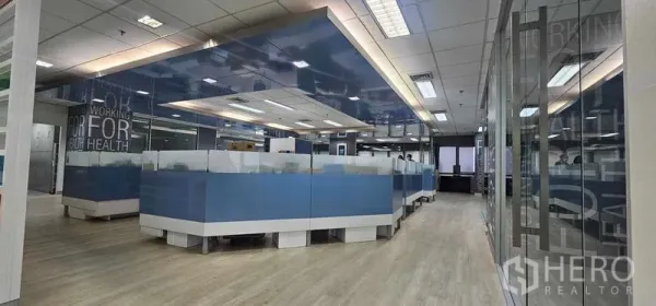 Office Space for rent in Bang Rak, Bangkok - Open-plan workspace featuring blue workstations, suspended ceiling lighting and glass walls in Bang Rak.