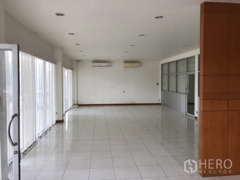 Factory for rent in Sai Noi, Nonthaburi - Bright office area with floor-to-ceiling windows and tiled flooring.