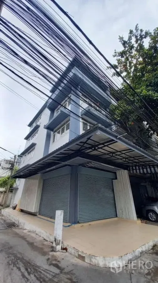 อาคารพาณิชย์ ให้เช่าในBangkok - มุมมองริมถนนของอาคารพาณิชย์ พร้อมกันสาดกว้างและประตูลูกกลิ้งคู่.