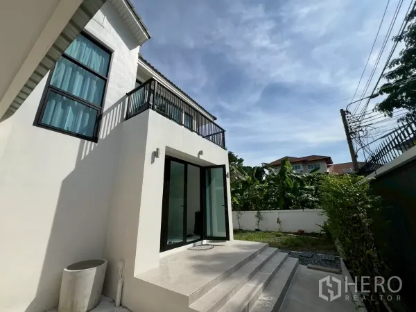 Detached House for rent in Suan Luang, Bangkok - Side entrance with steps and sliding glass doors opening to a small garden.