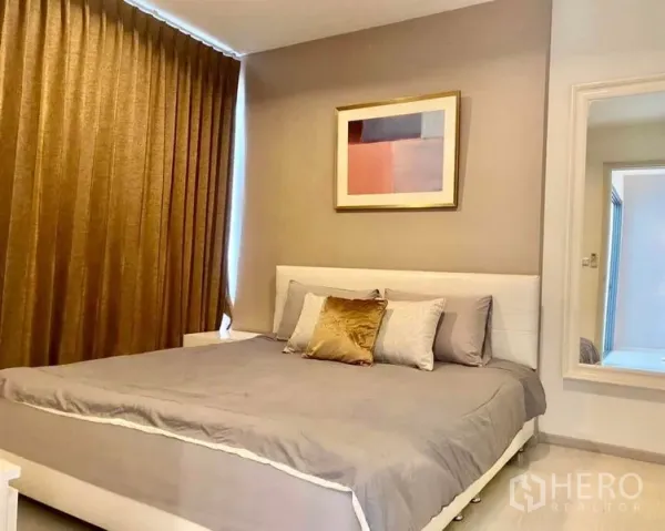 Condominium for rent in Khlong Toei, Bangkok - Cozy bedroom featuring a large bed, neutral tones, blackout curtains and framed artwork.