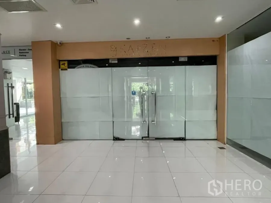 办公空间 出租在Ratchathewi, Bangkok - 光洁白砖地面上的商业单元玻璃双开门入口。