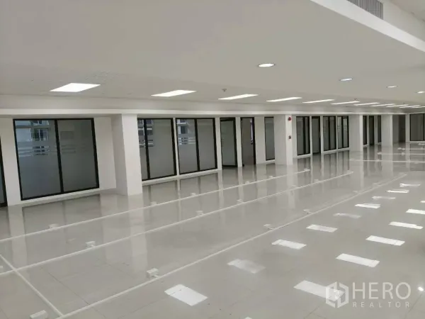 Office Space for rent in Chatuchak, Bangkok - Long open office floor with LED panel lights and glass partitions along the wall