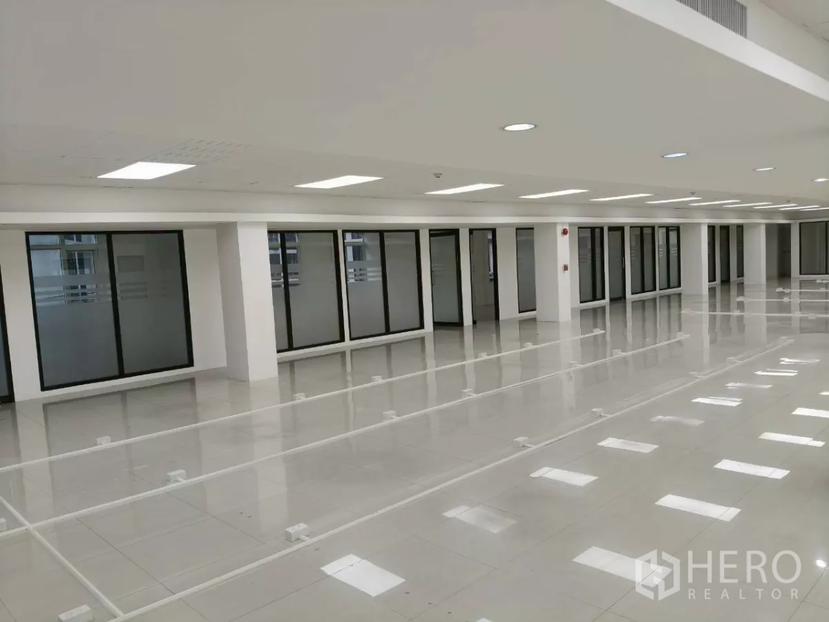 Office Space for rent in Chatuchak, Bangkok - Long open office floor with LED panel lights and glass partitions along the wall
