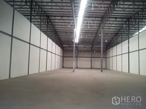 Warehouse for rent in Mueang Samut Sakhon, Samut Sakhon - Clean storage hall with high ceiling, central strip lighting and steel columns suitable for racking.
