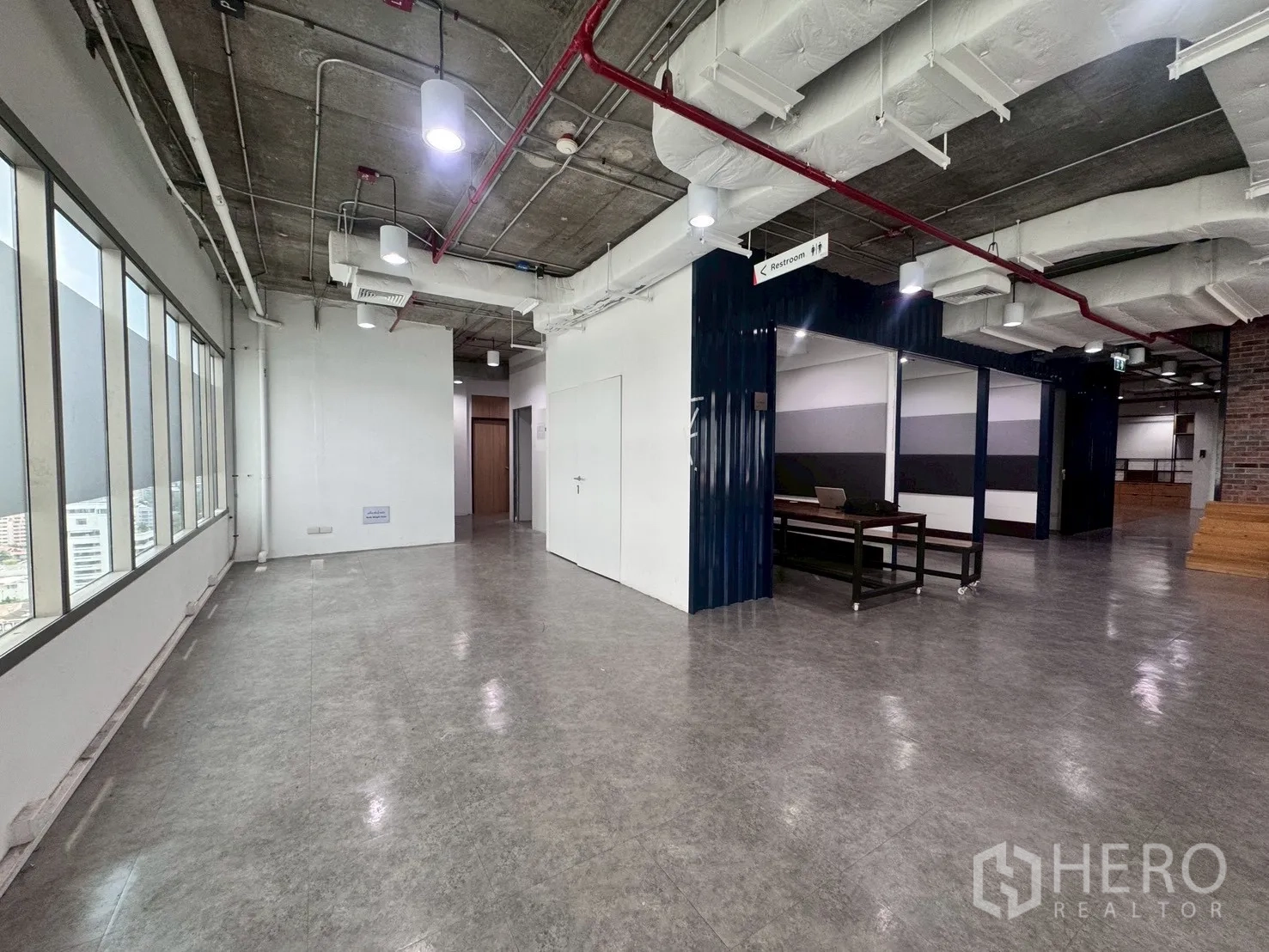 Office Space for rent in Watthana, Bangkok - Corner workspace with long window line and polished floors leading to interior rooms.