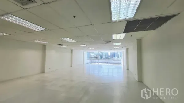 Office Space for rent in Khlong Toei, Bangkok - Spacious white office floor with grid ceiling lights and strong natural light from large windows.