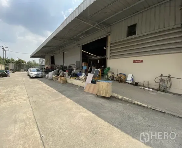 工厂 出售在Khlong Luang, Pathum Thani - 仓库正面，卷闸门开启的装卸月台与宽车道。