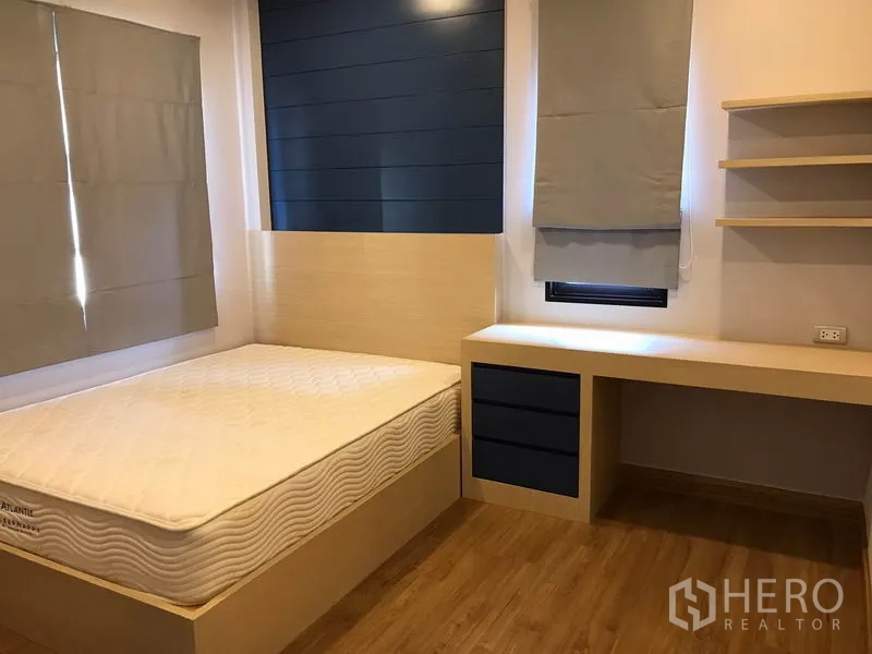 独立式住宅 出租在Bang Phli, Samut Prakan - 温馨卧室，带内置书桌与搁架、单人床和蓝色特色墙。