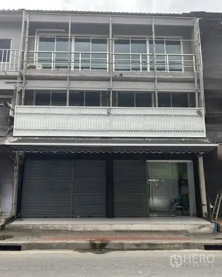 店屋 出租在Huai Khwang, Bangkok - 临街商业建筑正面，门面宽阔，推拉窗与阳台，前方人行道。