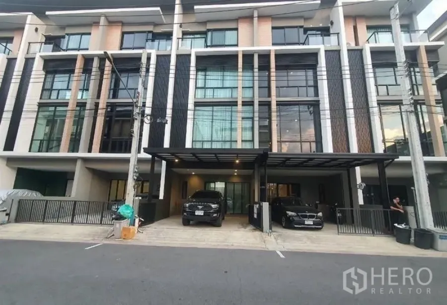 Home Office for rent in Lat Phrao, Bangkok - Modern multi‑storey home office facade in Bangkok with large windows and a covered two‑car carport.