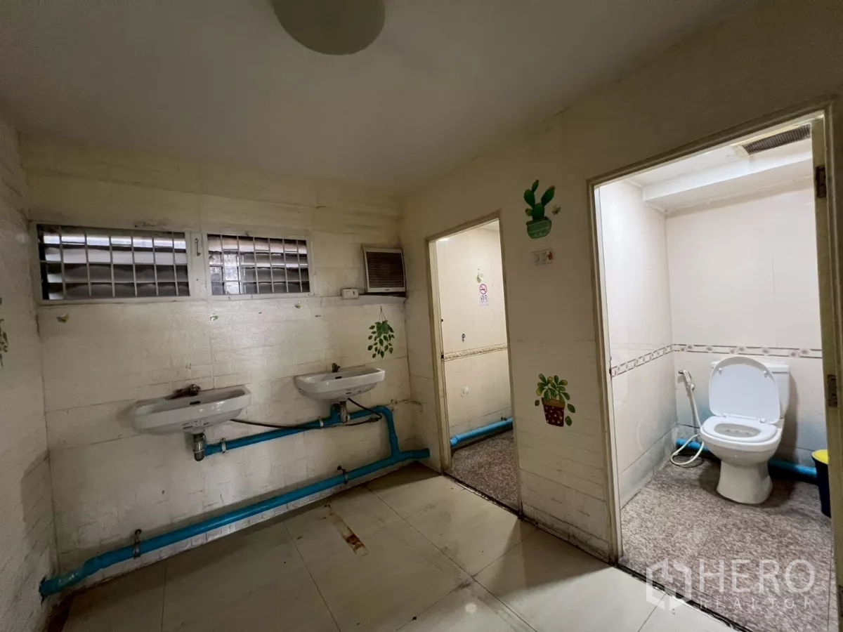 Shophouse for rent in Watthana, Bangkok - Restroom with dual sinks and separate toilet cubicles.