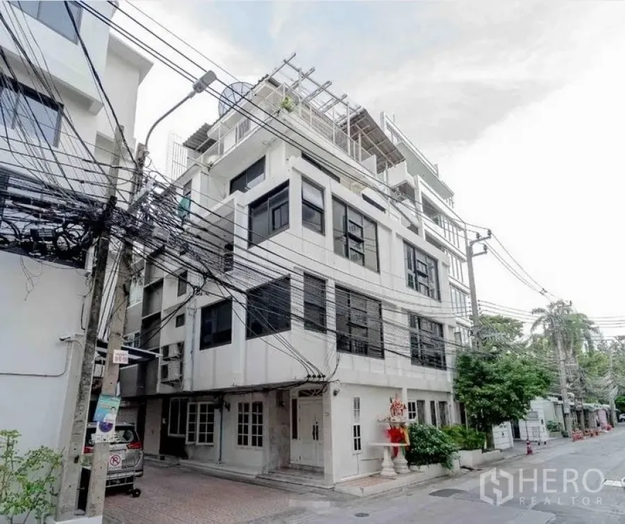 สำนักงานที่บ้าน ให้เช่าในBang Rak, Bangkok - ภาพถนนหน้าอาคารโฮมออฟฟิศสีขาวหลายชั้นพร้อมระเบียงและสายไฟเหนือศีรษะ