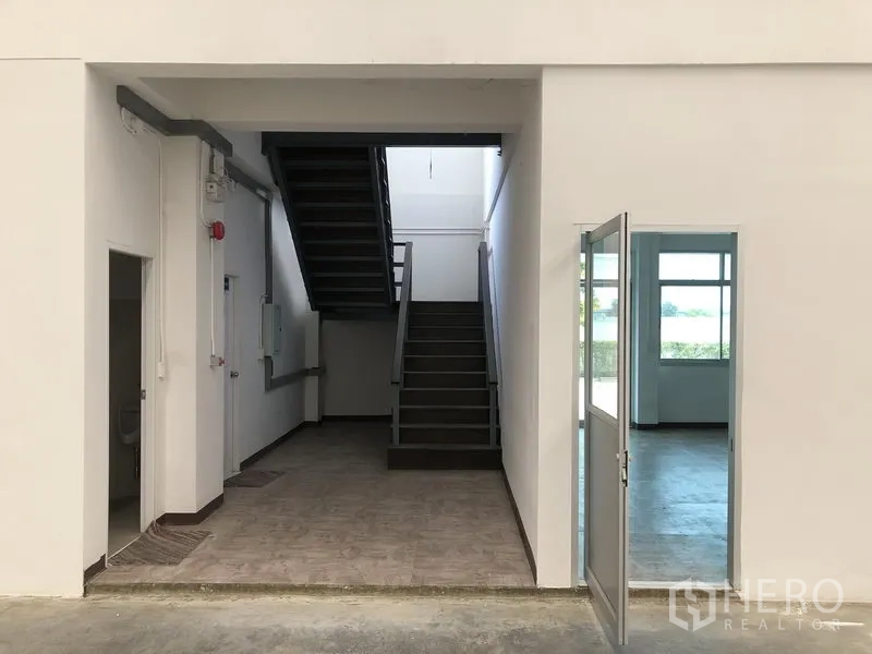 Factory for rent in Phra Nakhon Si Ayutthaya - Ground-floor entry with staircase to mezzanine and adjacent service rooms.
