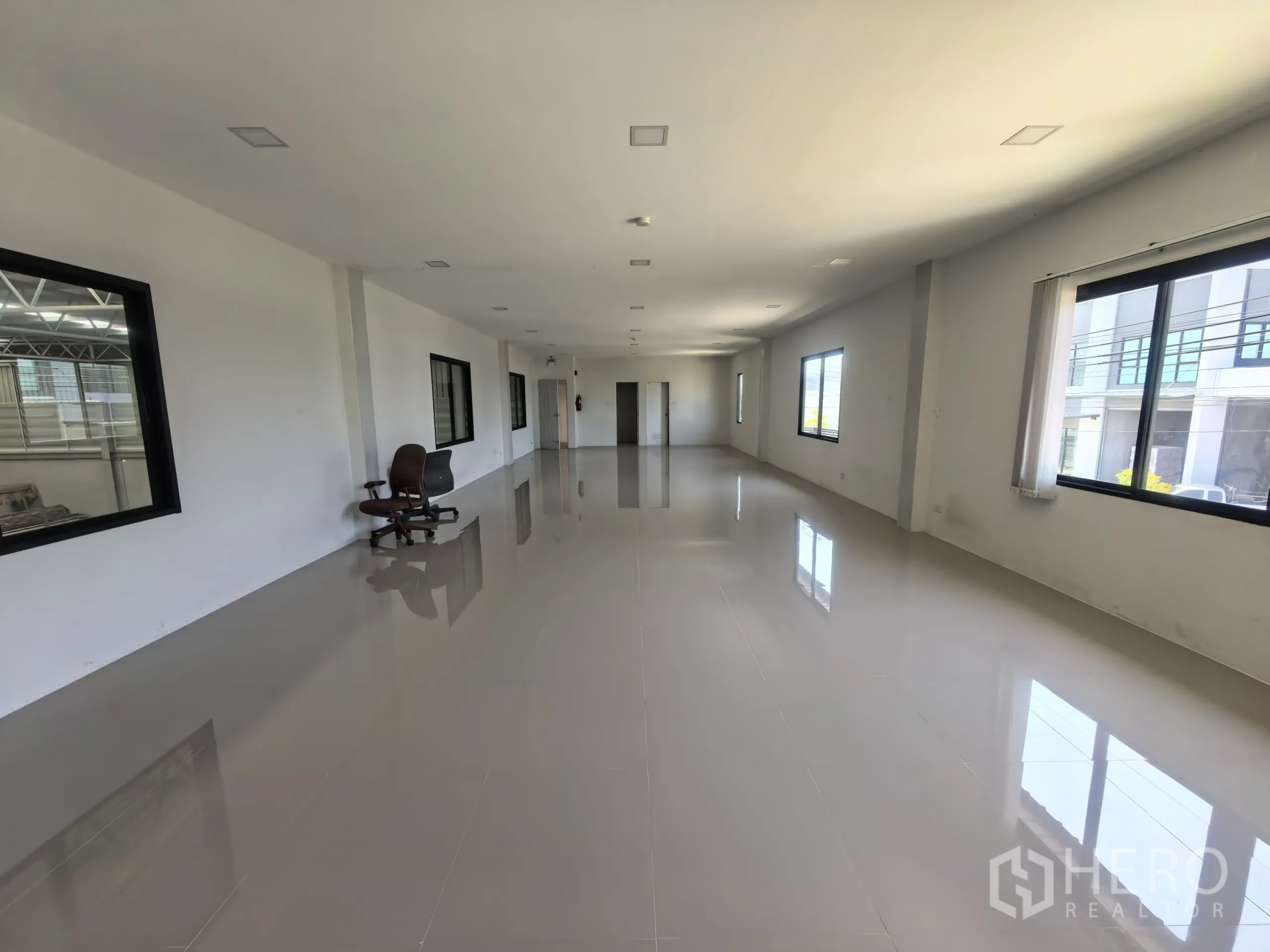 Factory for rent or sale in Khlong Toei, Bangkok - Open‑plan office zone with windows overlooking the factory floor and space for workstations.