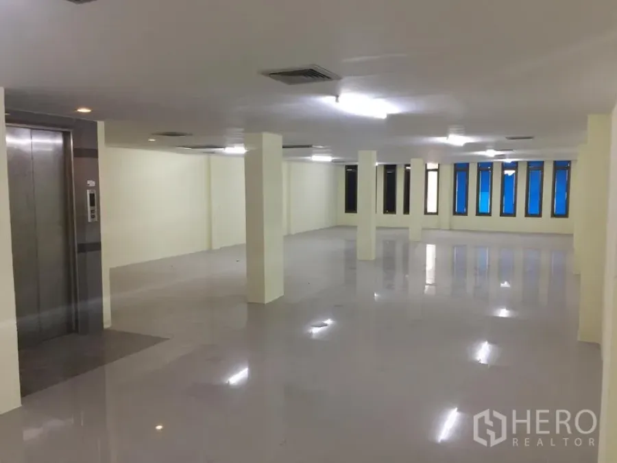 带办公室的家 出租在Watthana, Bangkok - 开放办公区，承重柱与荧光照明，长排窗户，旁设电梯厅。