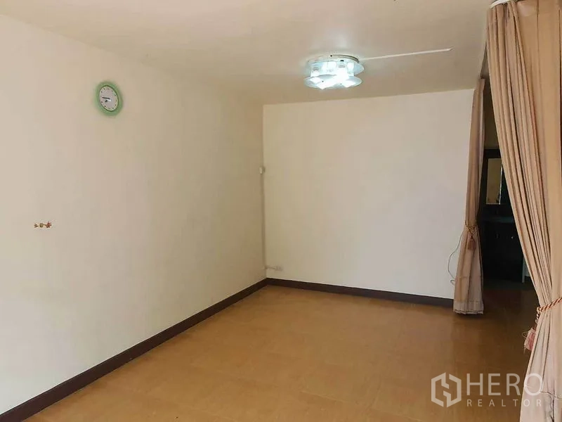 Townhouse for sale in Khlong Toei, Bangkok - Second living room with neutral walls, ceiling light, and curtain divider.
