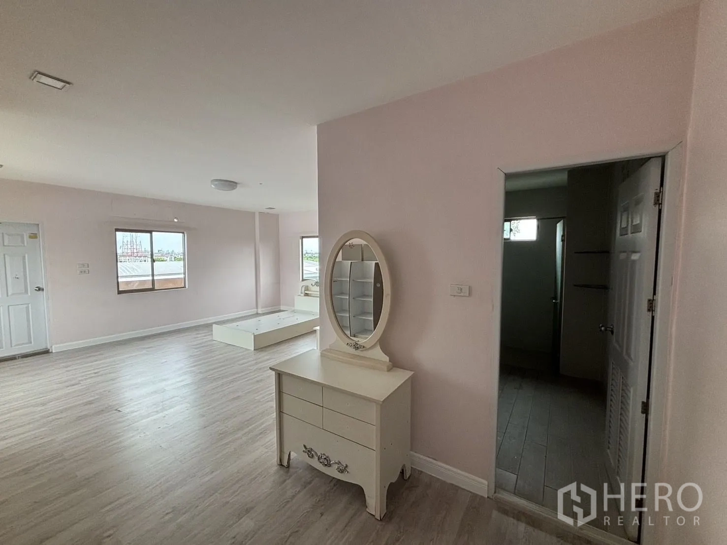 Warehouse for rent or sale in Wang Thonglang, Bangkok - Pink-toned bedroom with vanity table and balcony door.