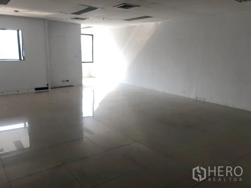 Office Space for rent in Watthana, Bangkok - Corner office area with strong natural light reflecting on polished tiles.