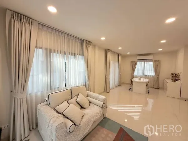 Detached House for sale in Bang Phli, Samut Prakan - Open-plan lounge with seating and study nook under recessed lighting and wide windows.
