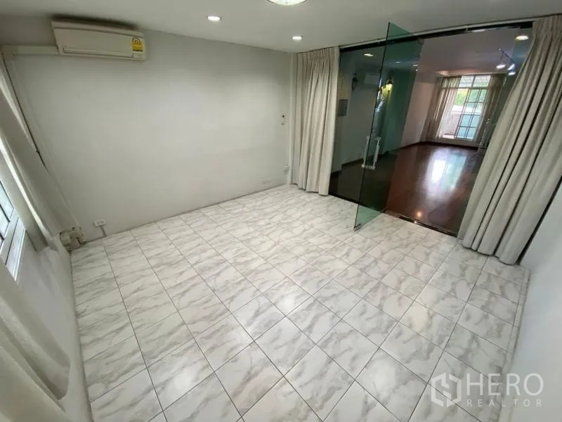 店屋 出租或出售在Watthana, Bangkok - 瓷砖会议室，经玻璃门连接到木地板起居区。