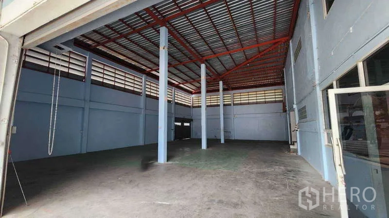Factory for rent in Pak Kret, Nonthaburi - High-ceiling warehouse interior with steel trusses and support columns