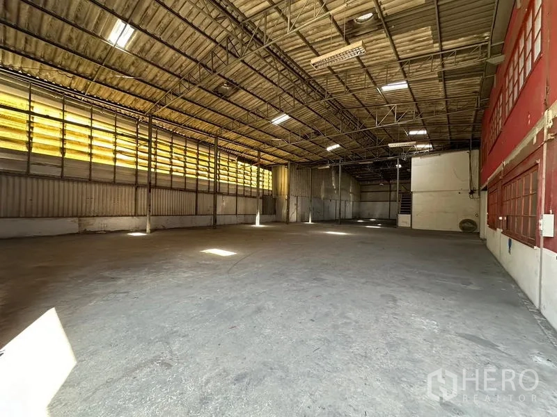 货栈 出租在Suan Luang, Bangkok - 大型仓储区，屋顶高挑，侧墙黄色透光板引入自然光。