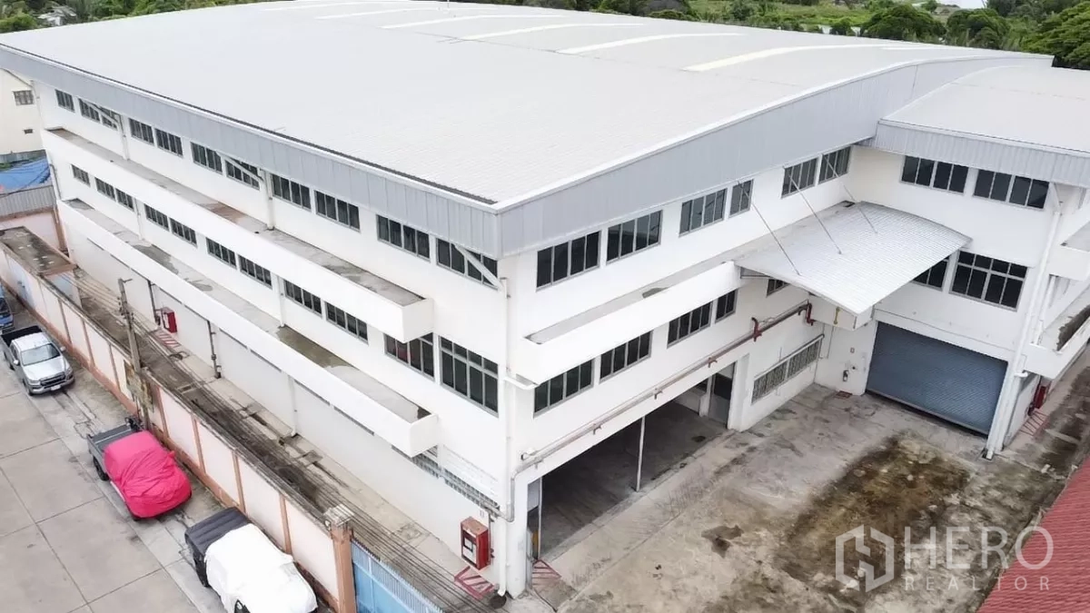 Factory for rent in Khlong Toei, Bangkok - Aerial view of a multi-storey factory with metal roof and loading yard.
