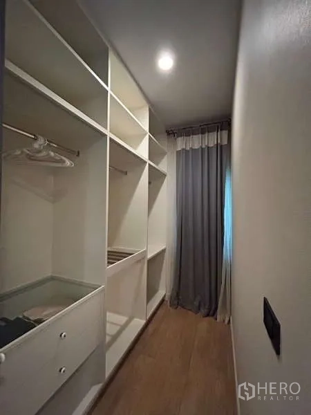 Detached House for rent in Bang Kapi, Bangkok - Compact walk-in closet with white shelving and hanging space.