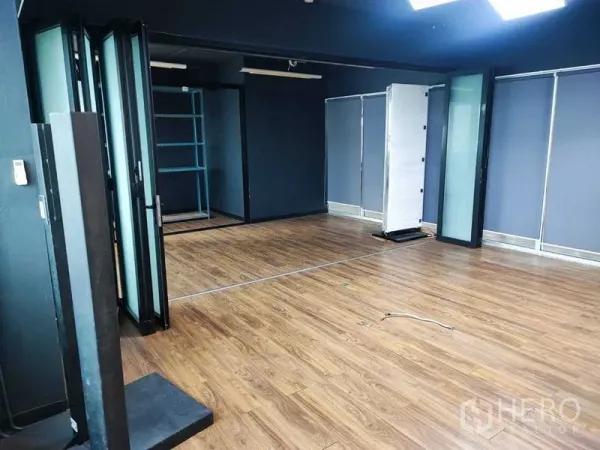 Office Space for rent in Watthana, Bangkok - Corner office space with dark ceiling, timber floors, and movable glass dividers.