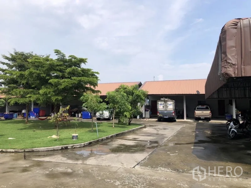 Detached House for sale in Lam Luk Ka, Pathum Thani - Courtyard with lawn, carports and driveways around the buildings.