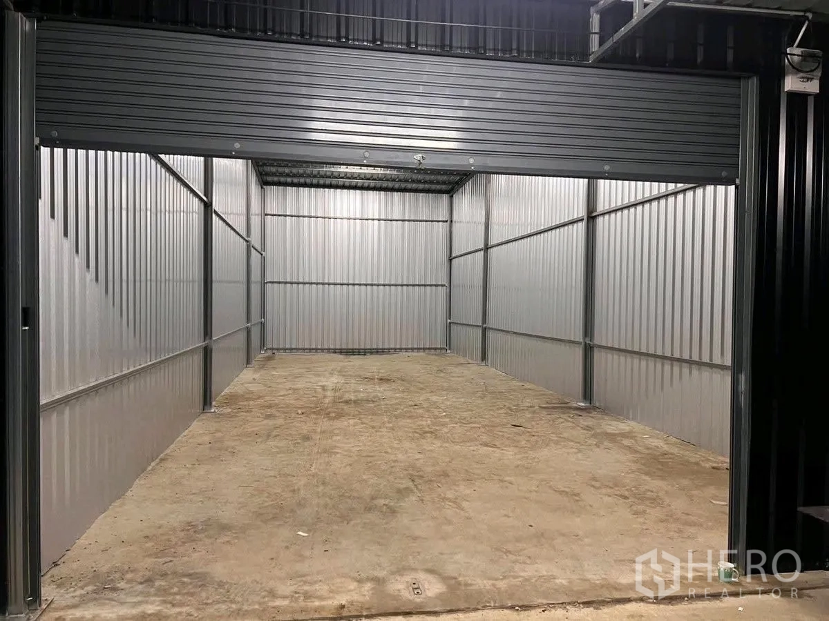 Warehouse for rent in Lat Krabang, Bangkok - Open warehouse bay with metal walls and a raised roller shutter door.
