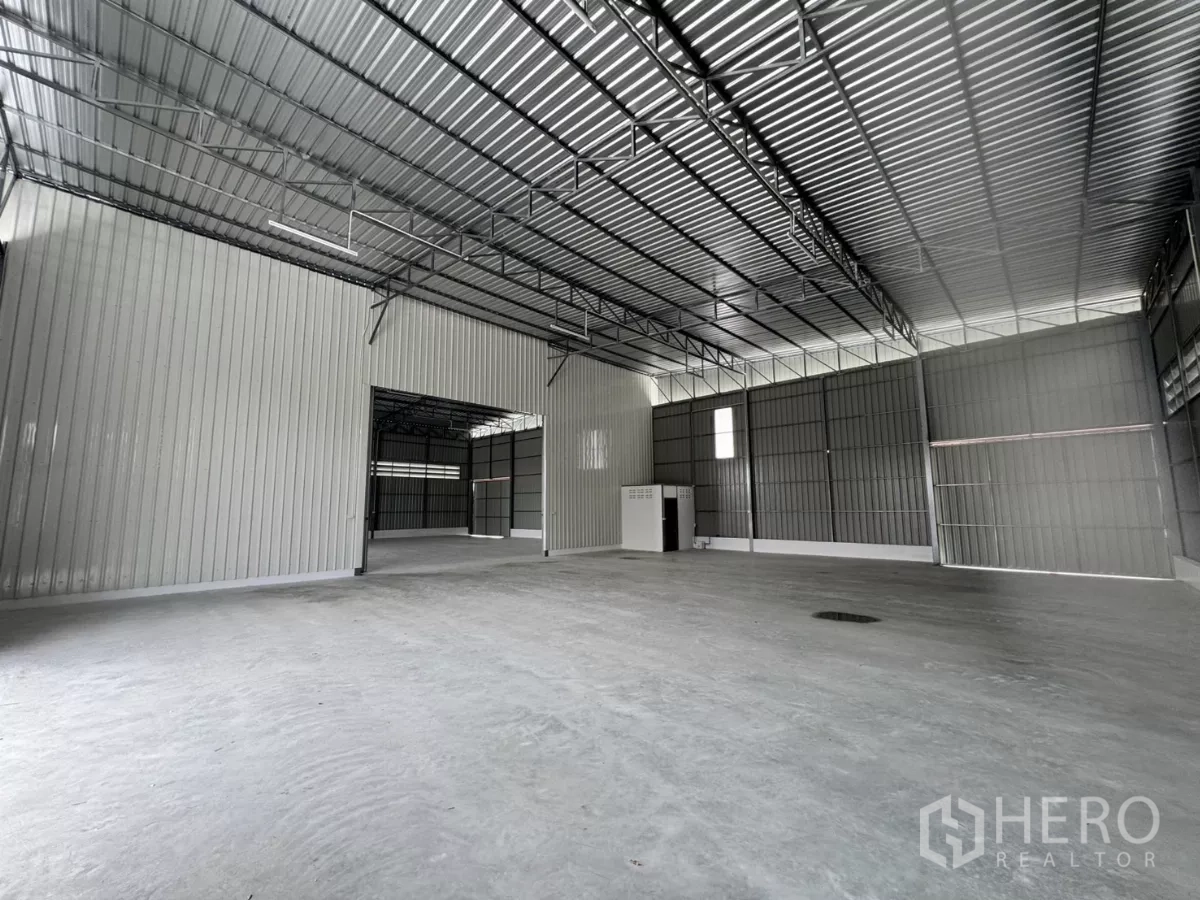 货栈 出租在Lam Luk Ka, Pathum Thani - 仓库内部宽敞，高钢结构屋顶、混凝土地面和分隔的功能区。