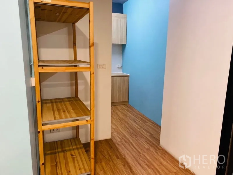 Office Space for rent in Bang Rak, Bangkok - Wood shelving in a corridor leading toward the kitchenette.
