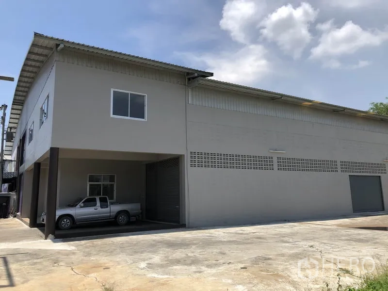 Factory for rent in Lat Lum Kaeo, Pathum Thani - Factory exterior with covered loading bay and roller shutter doors on a spacious apron