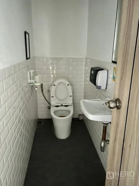 Retail Space for rent in Watthana, Bangkok - Compact restroom with white subway tiles, toilet and a small basin.