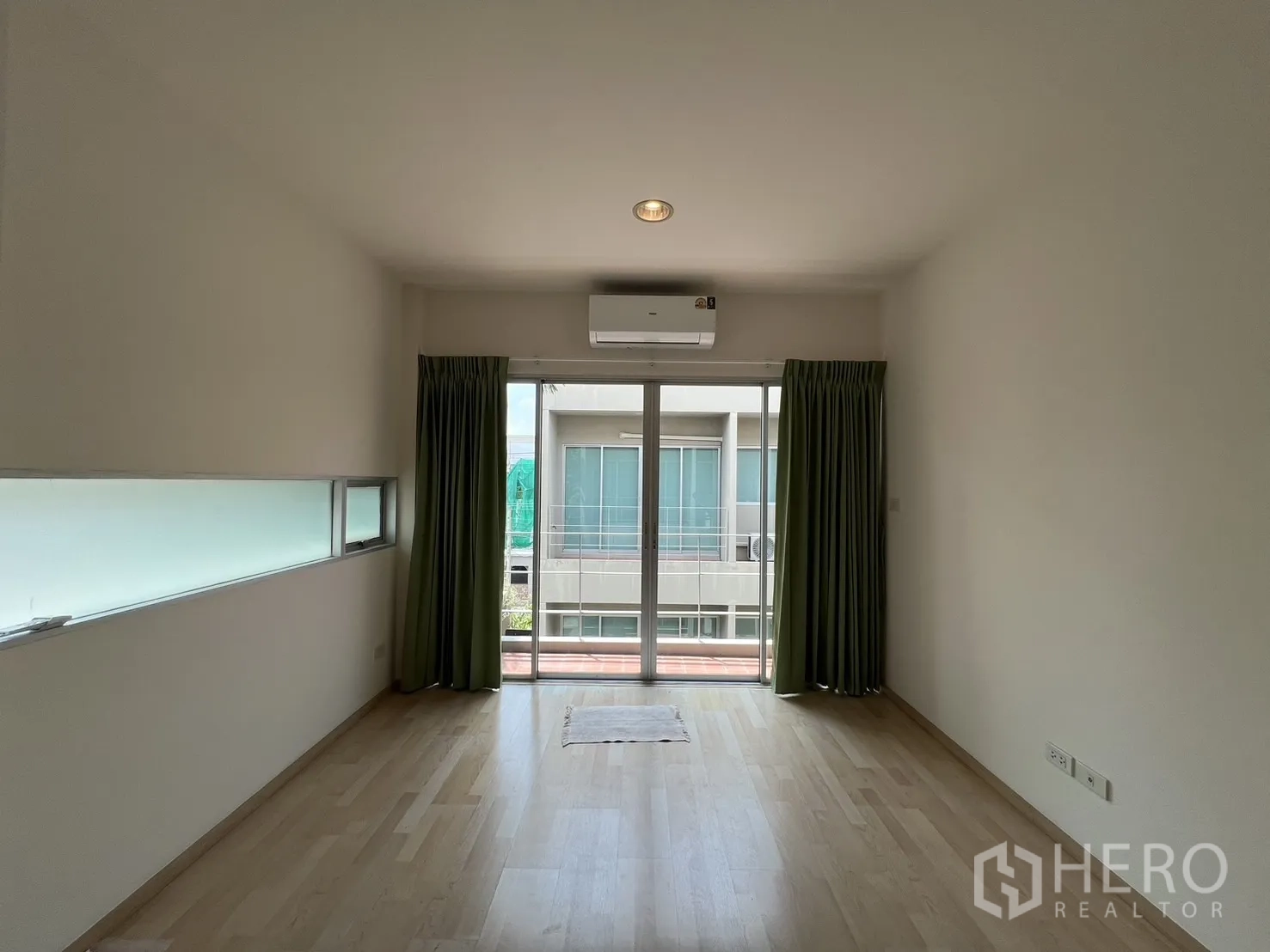 Townhouse for rent in Suan Luang, Bangkok - Another angle of the bedroom with wood floors and sliding glass doors.