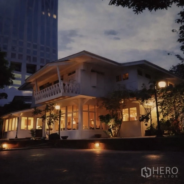 พื้นที่ขายปลีก for rent in Watthana, Bangkok - ภาพภายนอกช่วงค่ำของอาคารค้าปลีกสองชั้น ไฟสว่าง ระเบียง และกระจกโดยรอบ รายล้อมด้วยตึกสูง