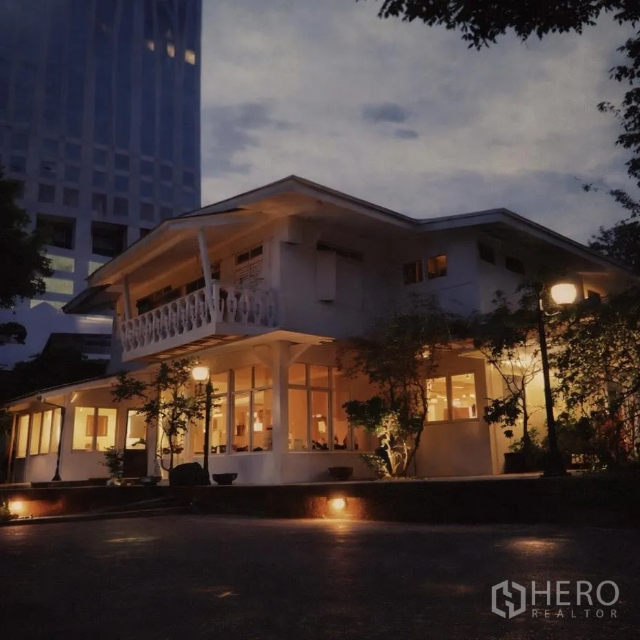 พื้นที่ขายปลีก for rent in Watthana, Bangkok - ภาพภายนอกช่วงค่ำของอาคารค้าปลีกสองชั้น ไฟสว่าง ระเบียง และกระจกโดยรอบ รายล้อมด้วยตึกสูง