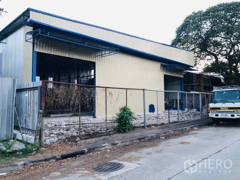 Warehouse for rent in Bang Kapi, Bangkok - Warehouse frontage with fence and large openings, suitable for loading and unloading.