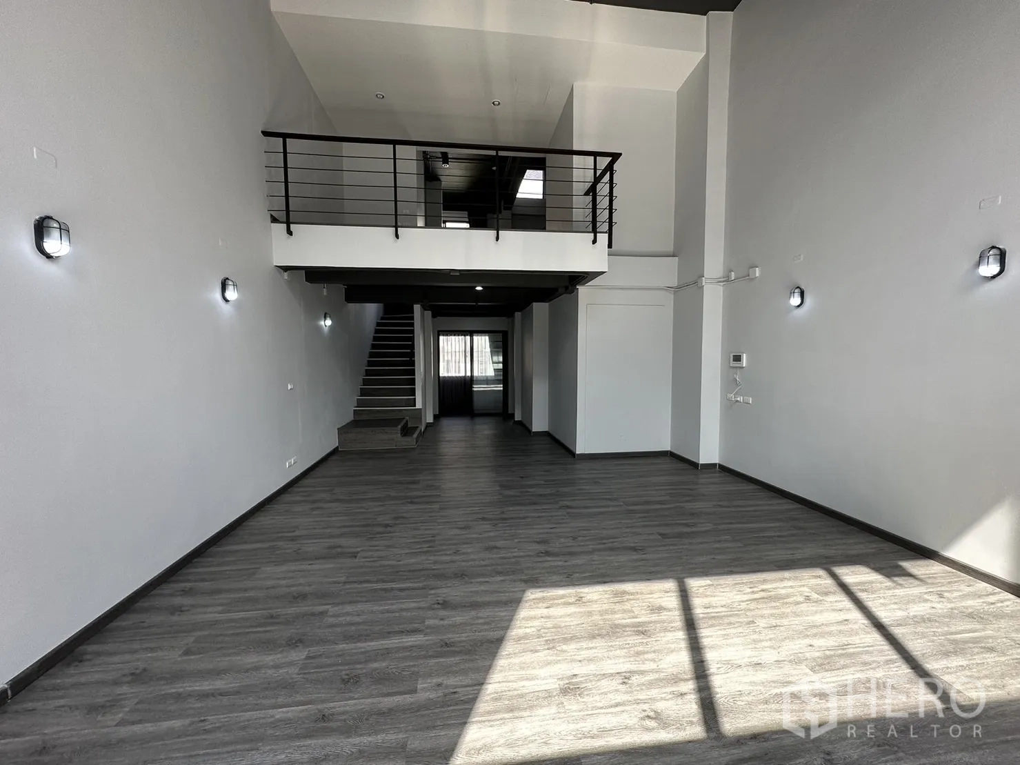 Home Office for rent or sale in Suan Luang, Bangkok - Open-plan area with high ceiling, mezzanine platform and a long central staircase.