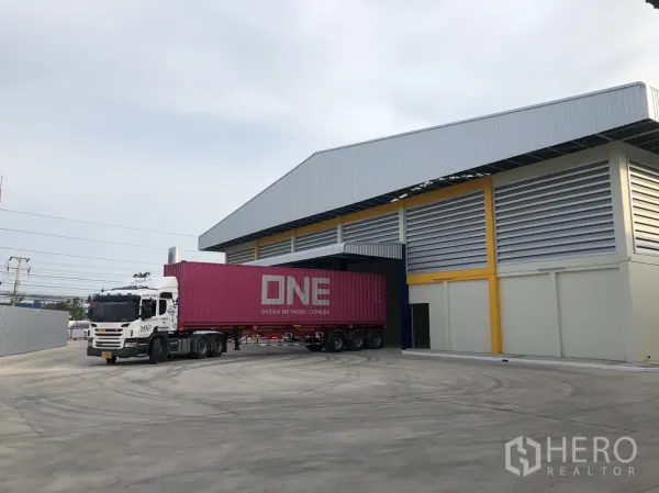 Factory for rent in Mueang Samut Sakhon, Samut Sakhon - Container truck accessing the warehouse under a covered loading bay, showing wide turning space for trailers.